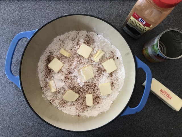 Pats of butter placed on top of the cake mix and cinnamon