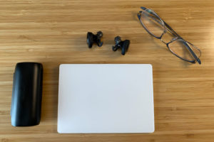 A pair of Bose headphones, a Mac trackpad, and a pair of glasses